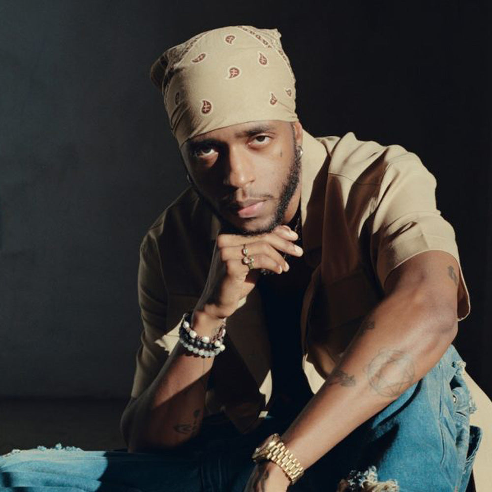 Official 6LACK portrait with separate tattoos visible on his forearm