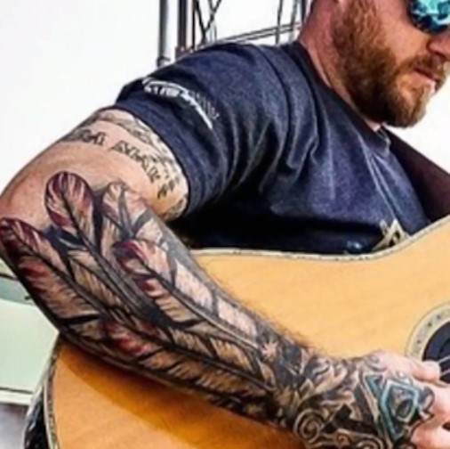 Cody Johnson tattoos: the tattooed arm sleeve and hand logos