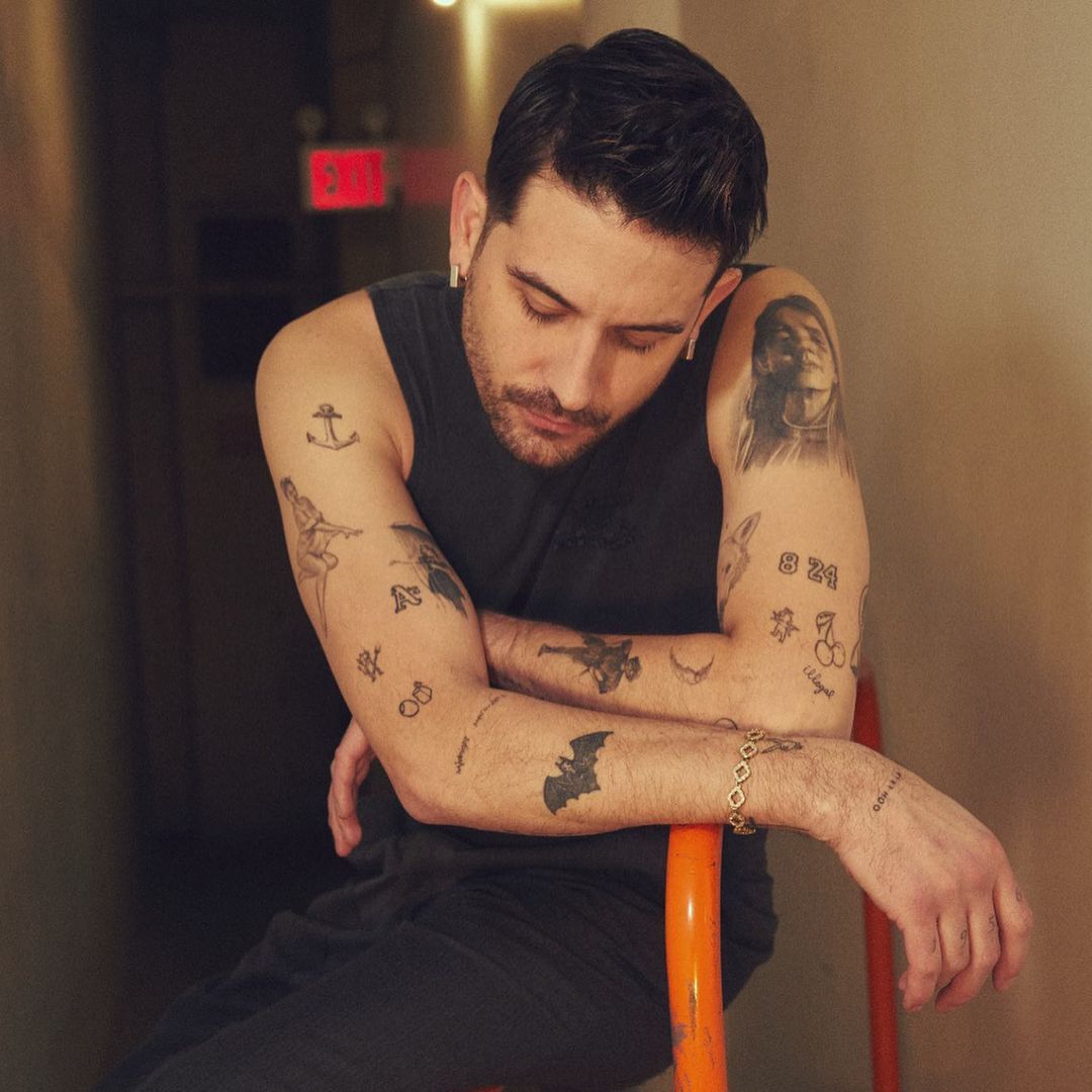 G-Eazy tattoos: both tattooed arms with anchor, portrait, number and traditional designs