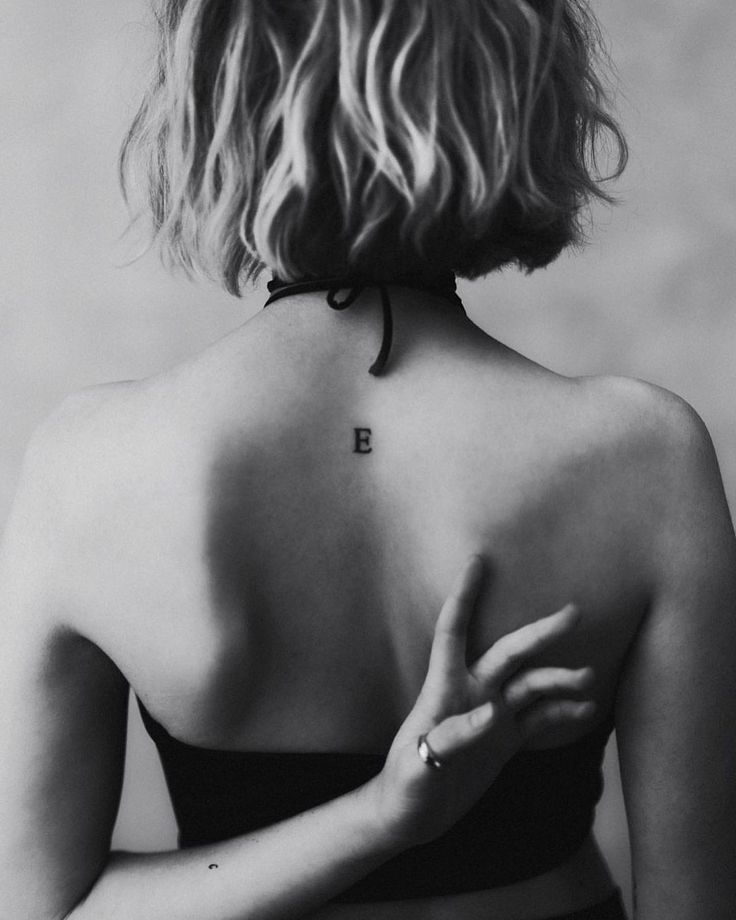 Milly Alcock tattoos: Milly Alcock upper-back E tattoo
