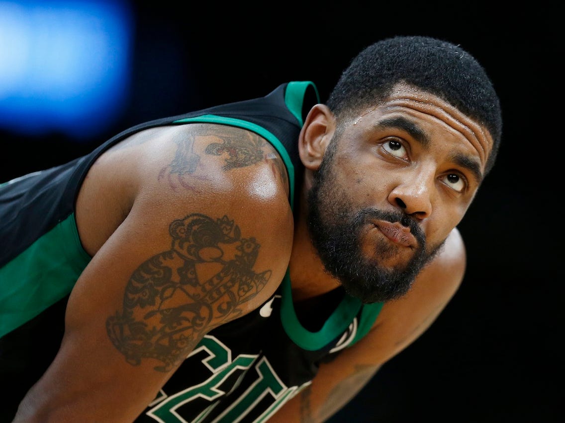 Kyrie Irving tattoos: high-resolution game photograph showing the visible upper-body tattoo placement beneath a jersey