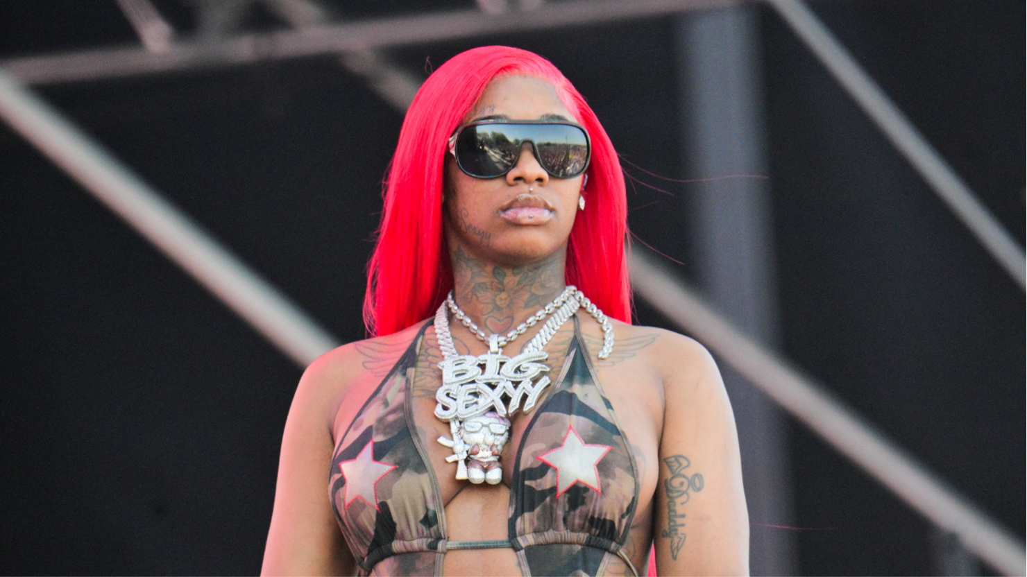 Sexyy Red tattoos: separate stage photograph showing the neck, chest and visible arm ink