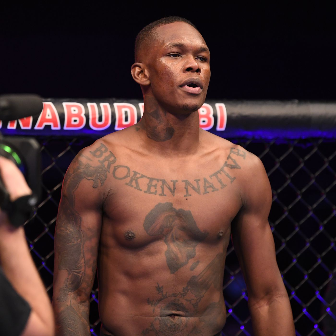 Israel Adesanya tattoos: high-resolution chest and torso photograph showing Broken Native, Africa and surrounding ink