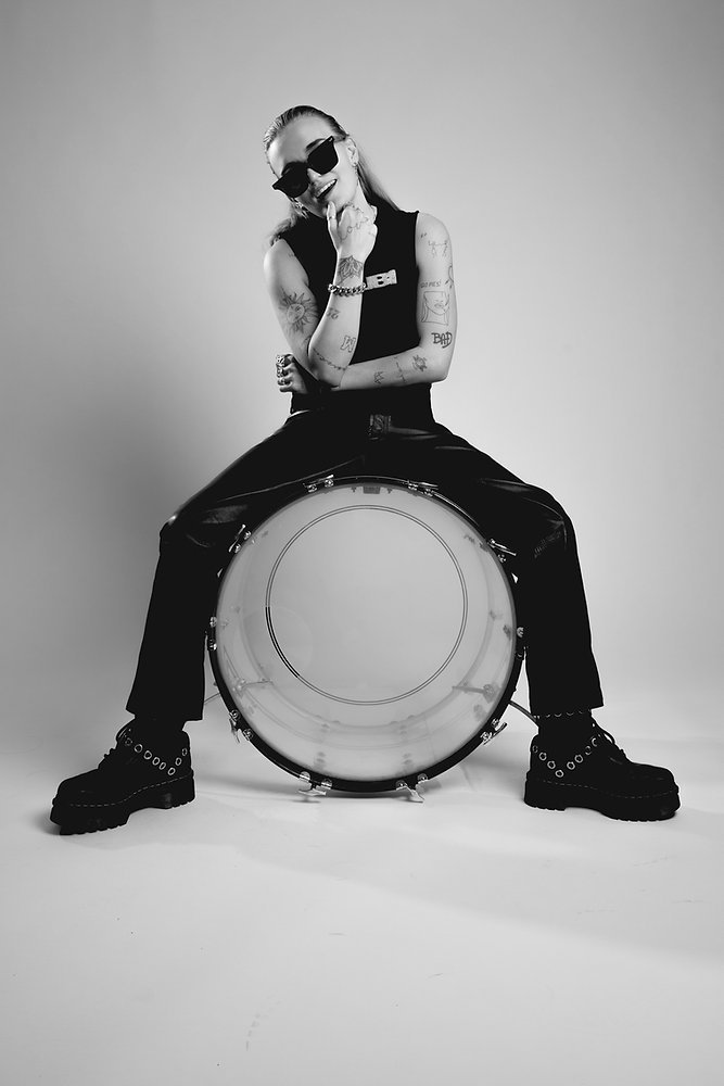 G Flip tattoos: distinct black-and-white drum portrait with visible arm tattoos