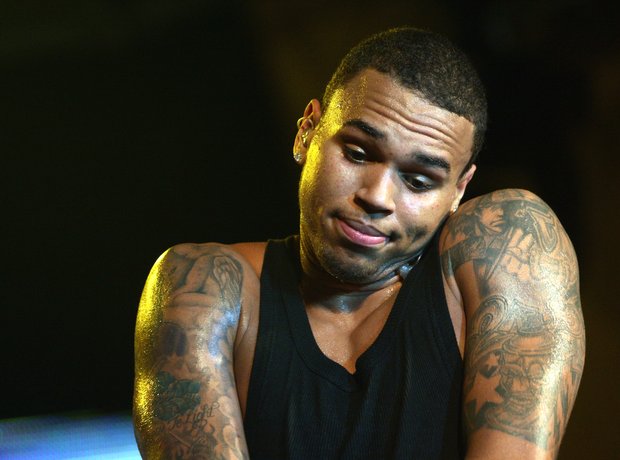 Chris Brown performing with his tattooed arms visible