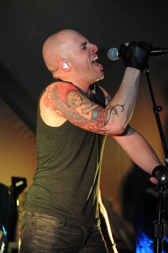 Chris Daughtry showing the angel and colorful tattoo sleeve on his upper arm