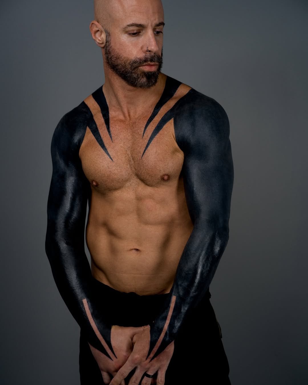 Chris Daughtry showing the solid blackout tattoos and pointed negative-space shoulder stripes