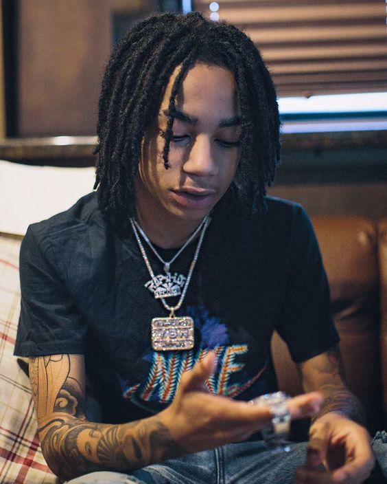 YBN Nahmir seated with both tattooed forearms visible