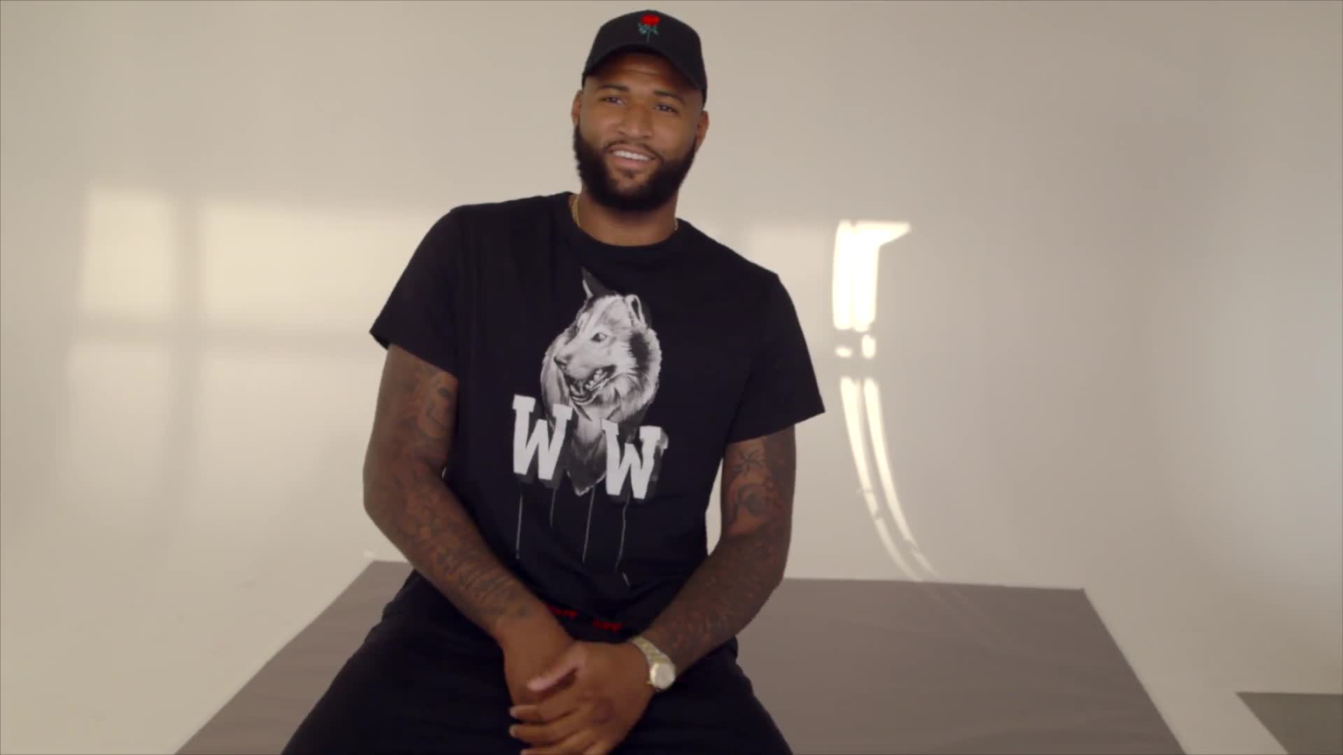 DeMarcus Cousins showing his tattoos during a GQ Tattoo Tour