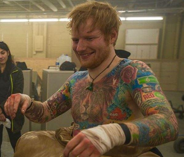 Ed Sheeran showing the Heinz ketchup bottle tattoo among his arm designs