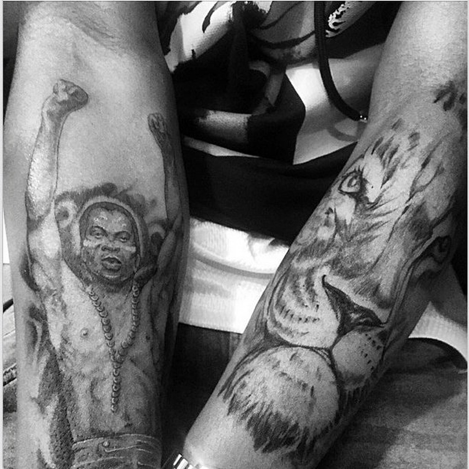Burna Boy tattoos: Distinct arm photograph showing portrait and lion tattoo work