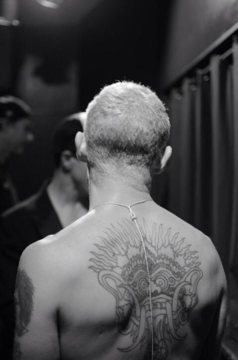 Flea showing the large radiating back design tattoo