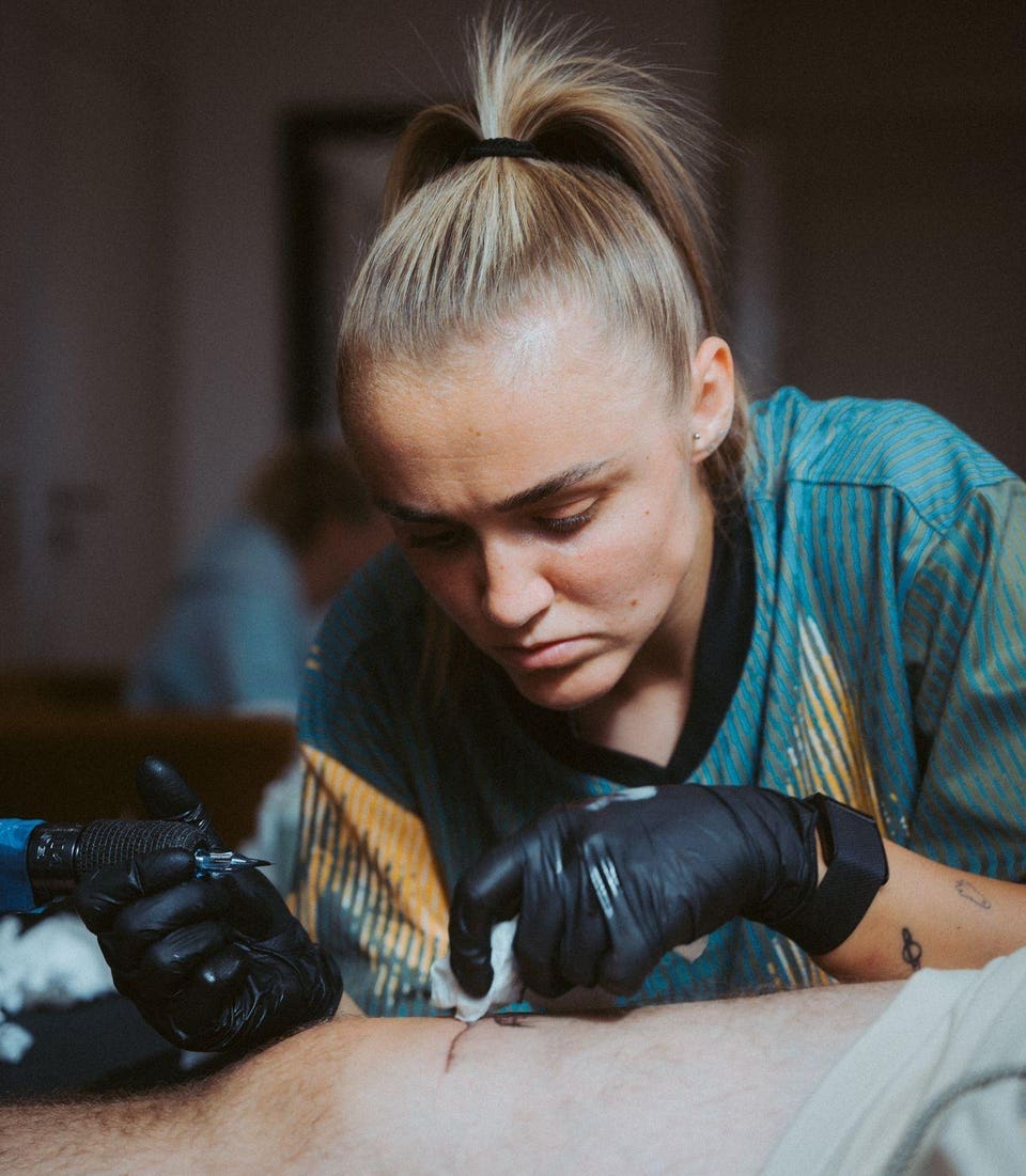 Georgia Stanway tattooing a client