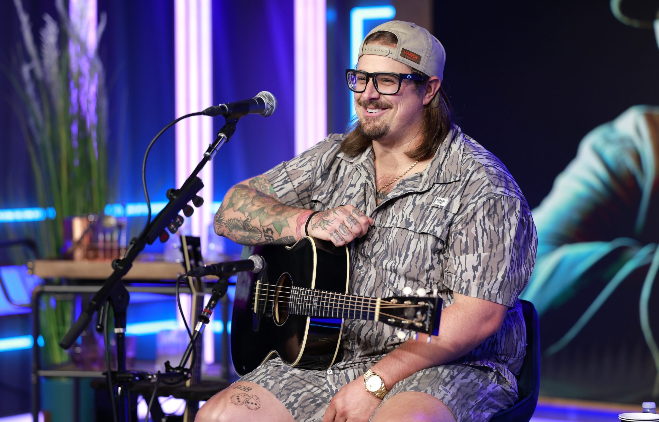 HARDY tattoos: HARDY arm sleeve and thigh tattoos during an acoustic performance
