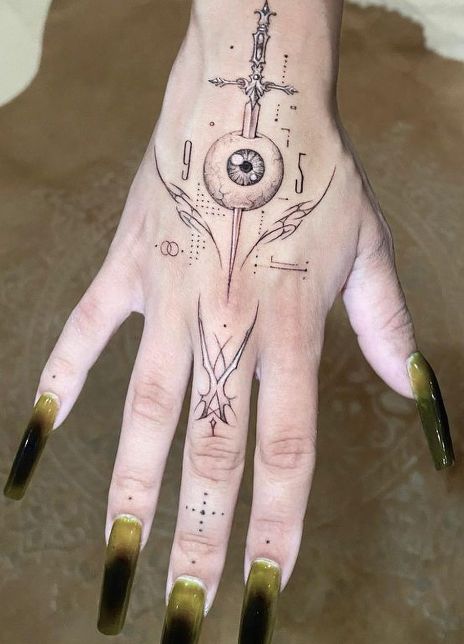 Doja Cat tattoos: high-detail close-up of Doja Cat’s sword-through-eye hand tattoo