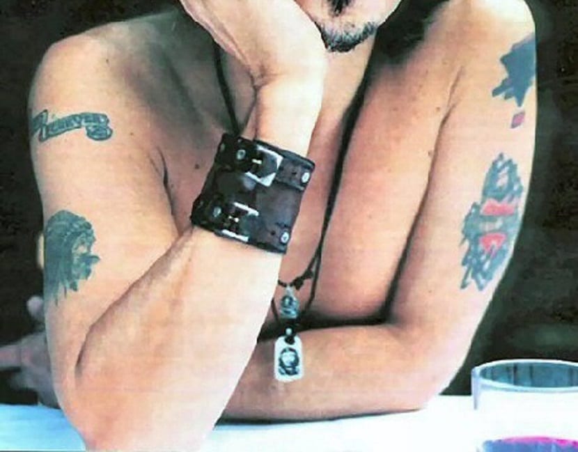 Johnny Depp tattoos visible across his upper body and arm