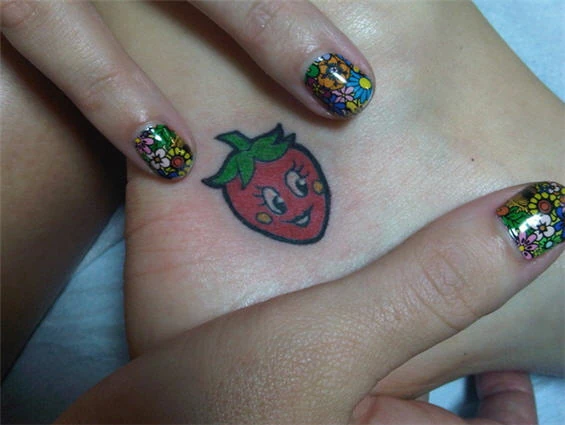 Katy Perry’s smiling strawberry ankle tattoo