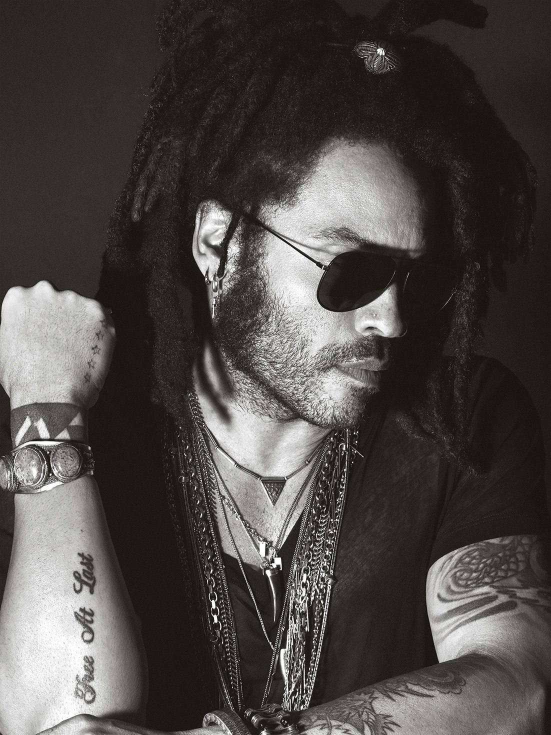Lenny Kravitz portrait showing Free At Last forearm lettering