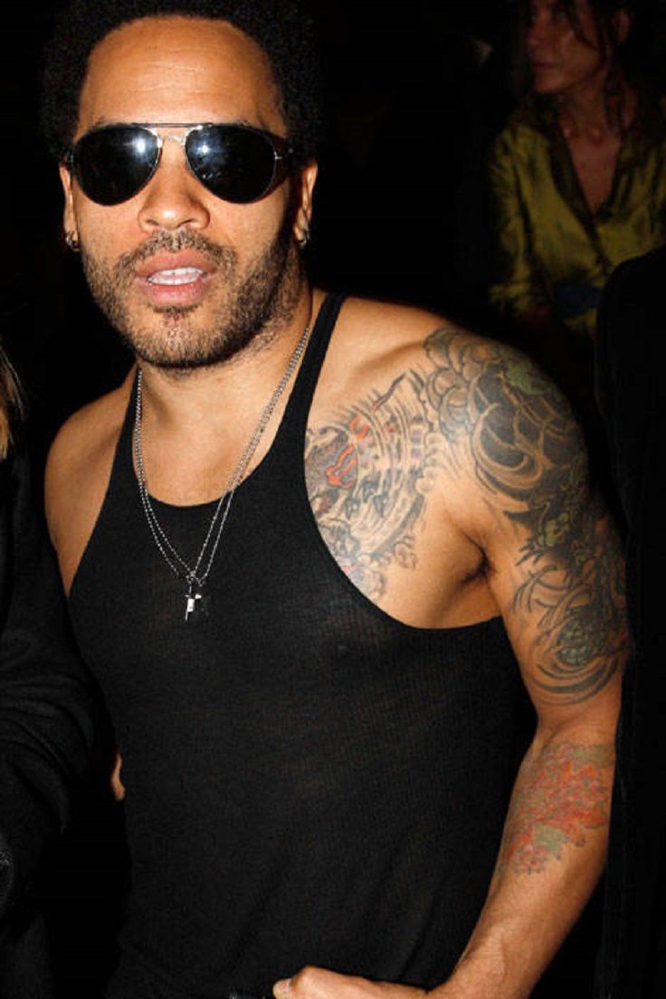 Lenny Kravitz arrow cross and upper-arm tattoo detail