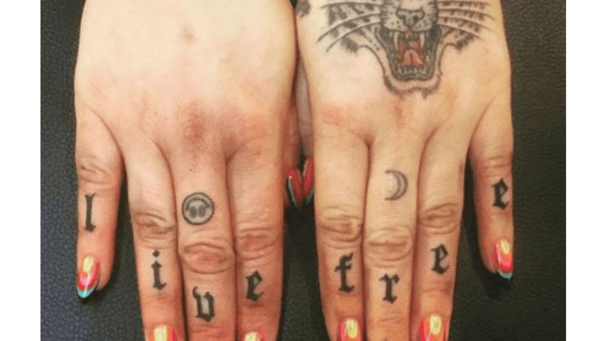 Kesha tattoos: clear close-up of Kesha's LIVE FREE knuckle lettering