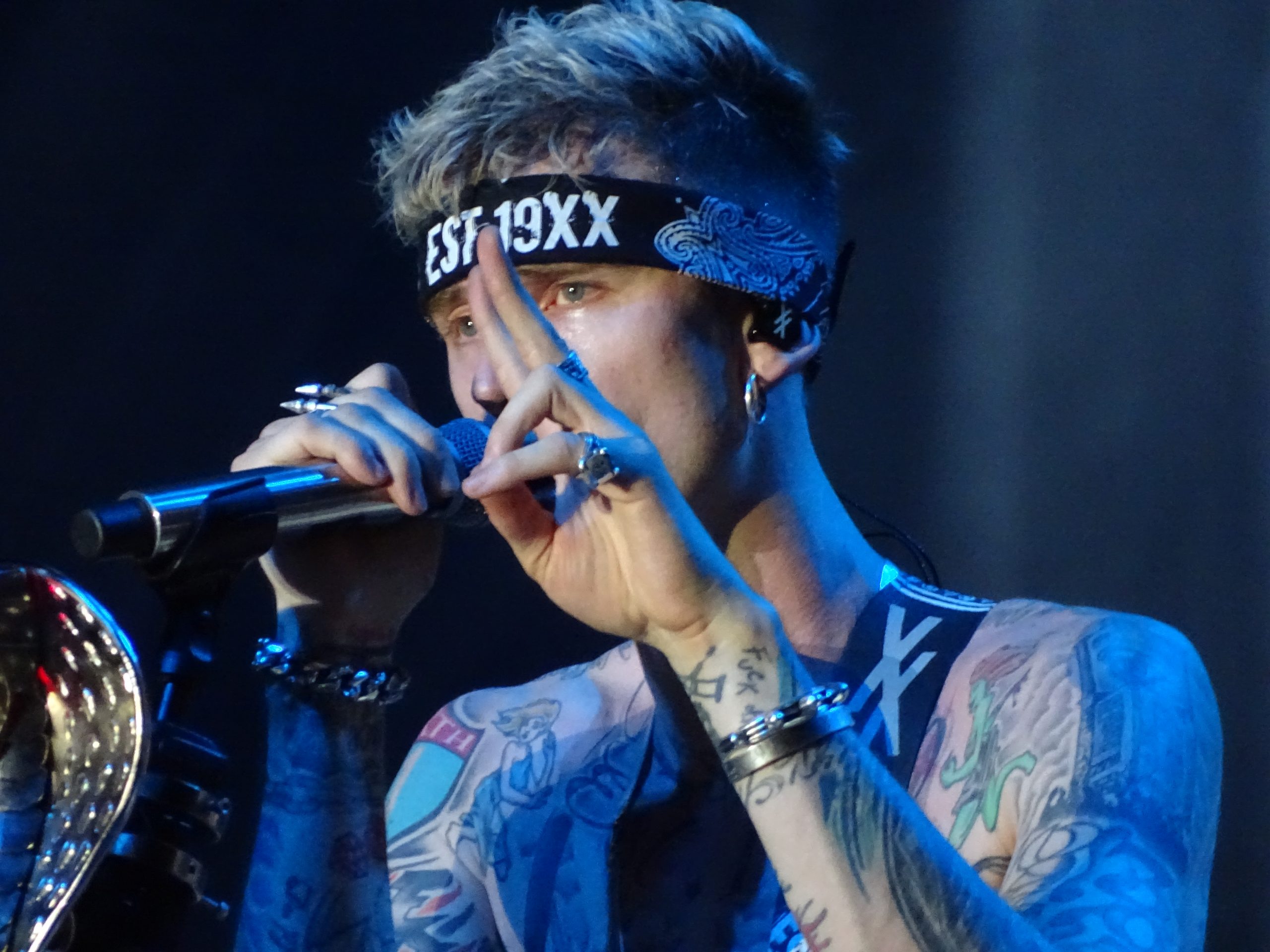 Machine Gun Kelly performing in 2018 with his pre-blackout chest and neck tattoos visible