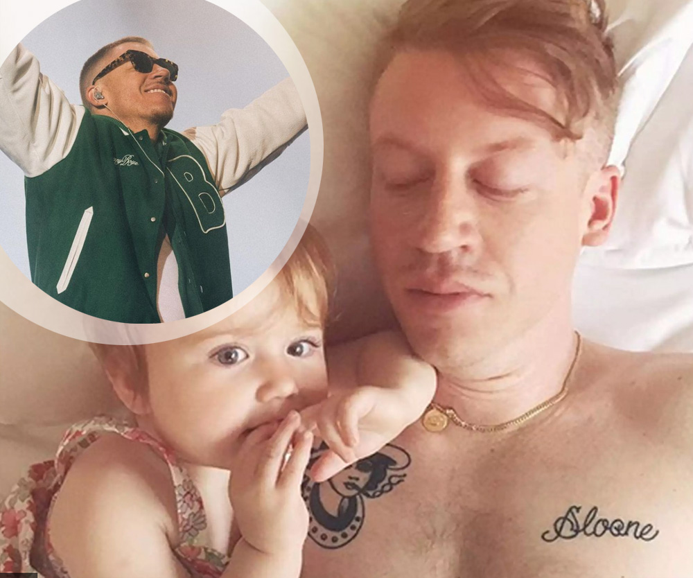 Macklemore holding his daughter, with the Sloane lettering tattoo visible on his chest