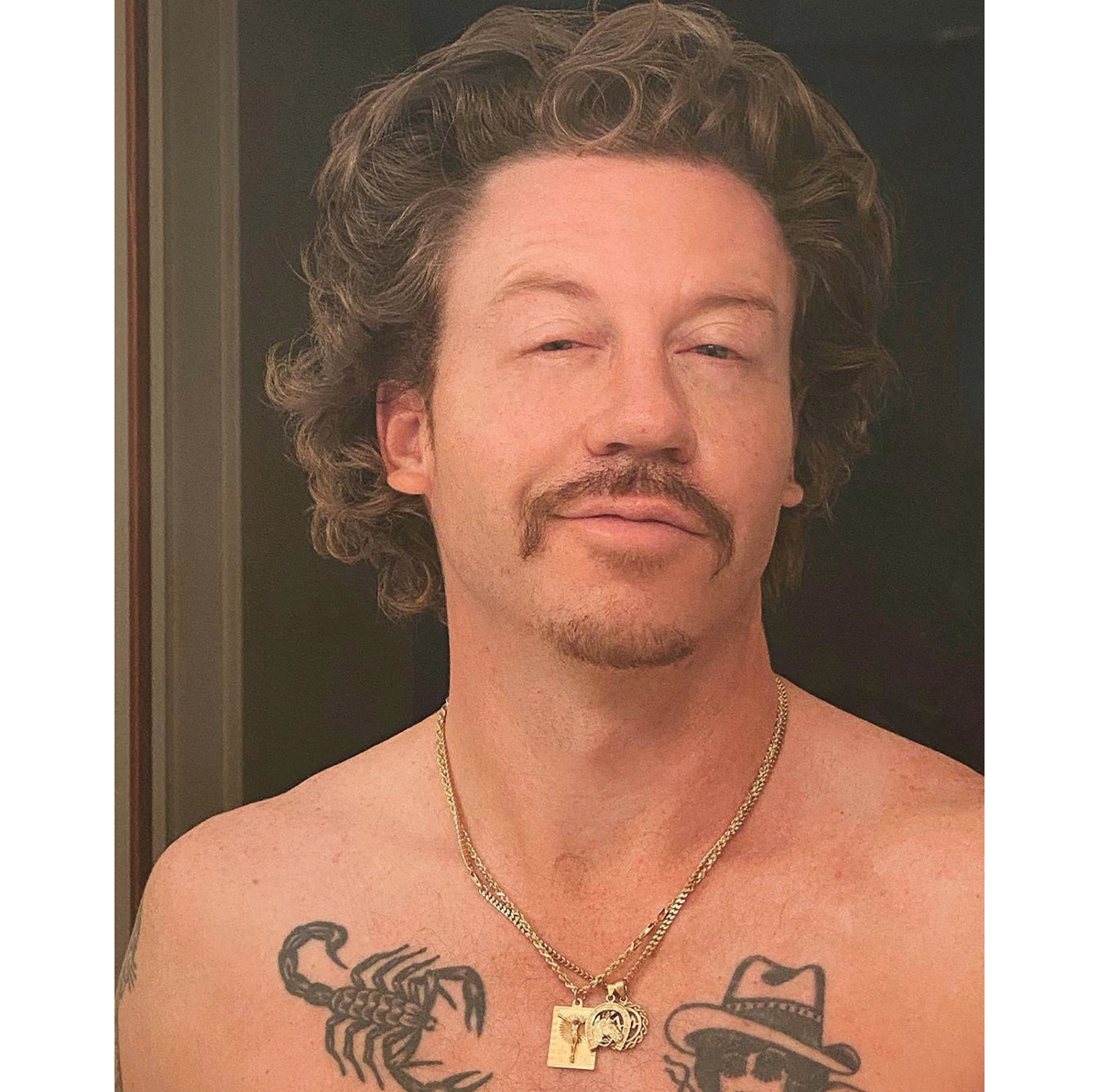 Close view of Macklemore’s chest tattoos, including traditional-style illustrated designs
