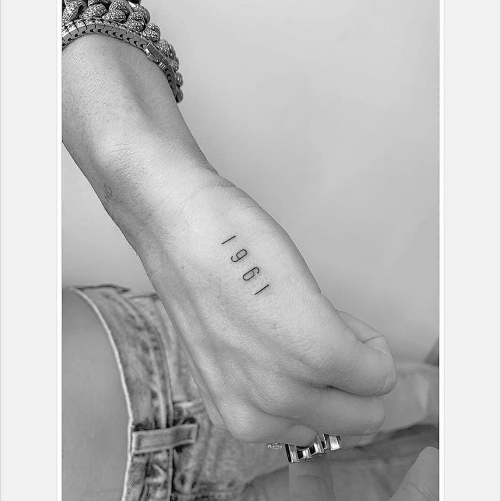 Miley Cyrus showing the 1961 hand tattoo