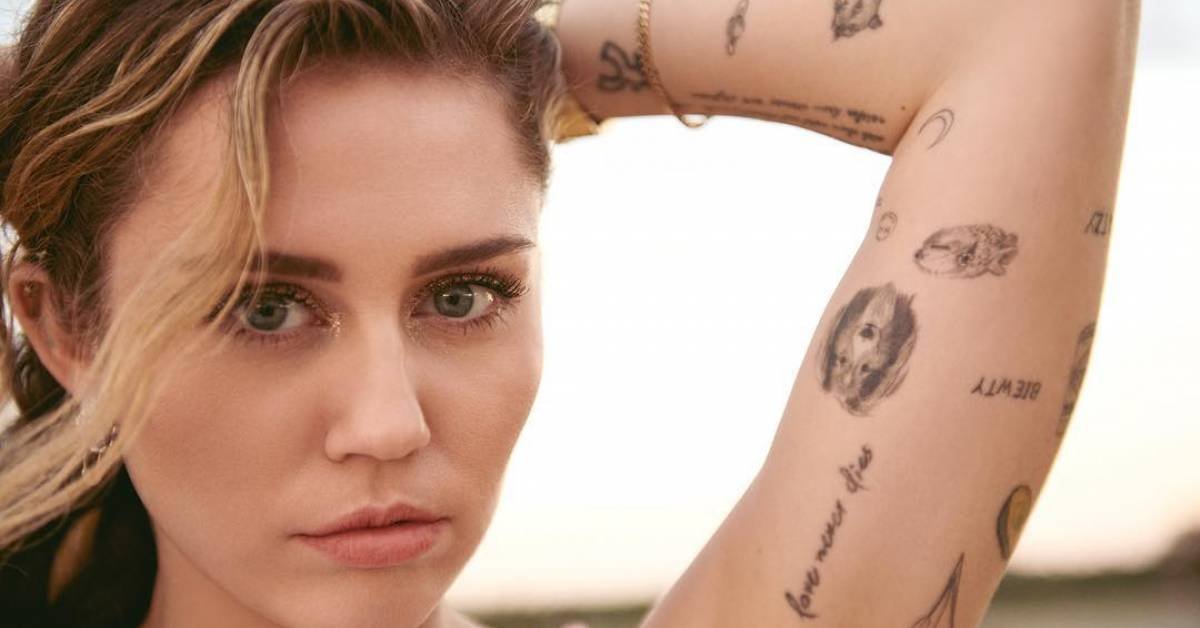 Miley Cyrus showing the Love Never Dies arm tattoo