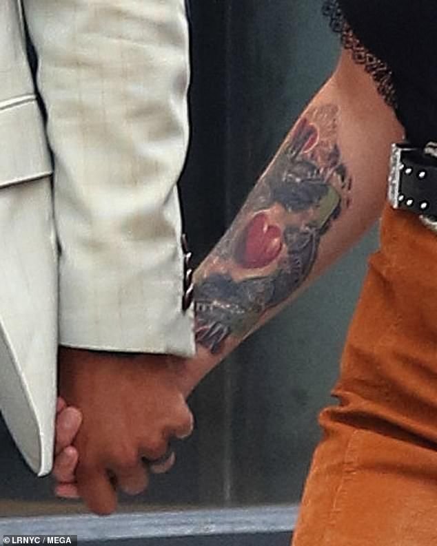 Miranda Lambert showing a colorful heart tattoo on her forearm