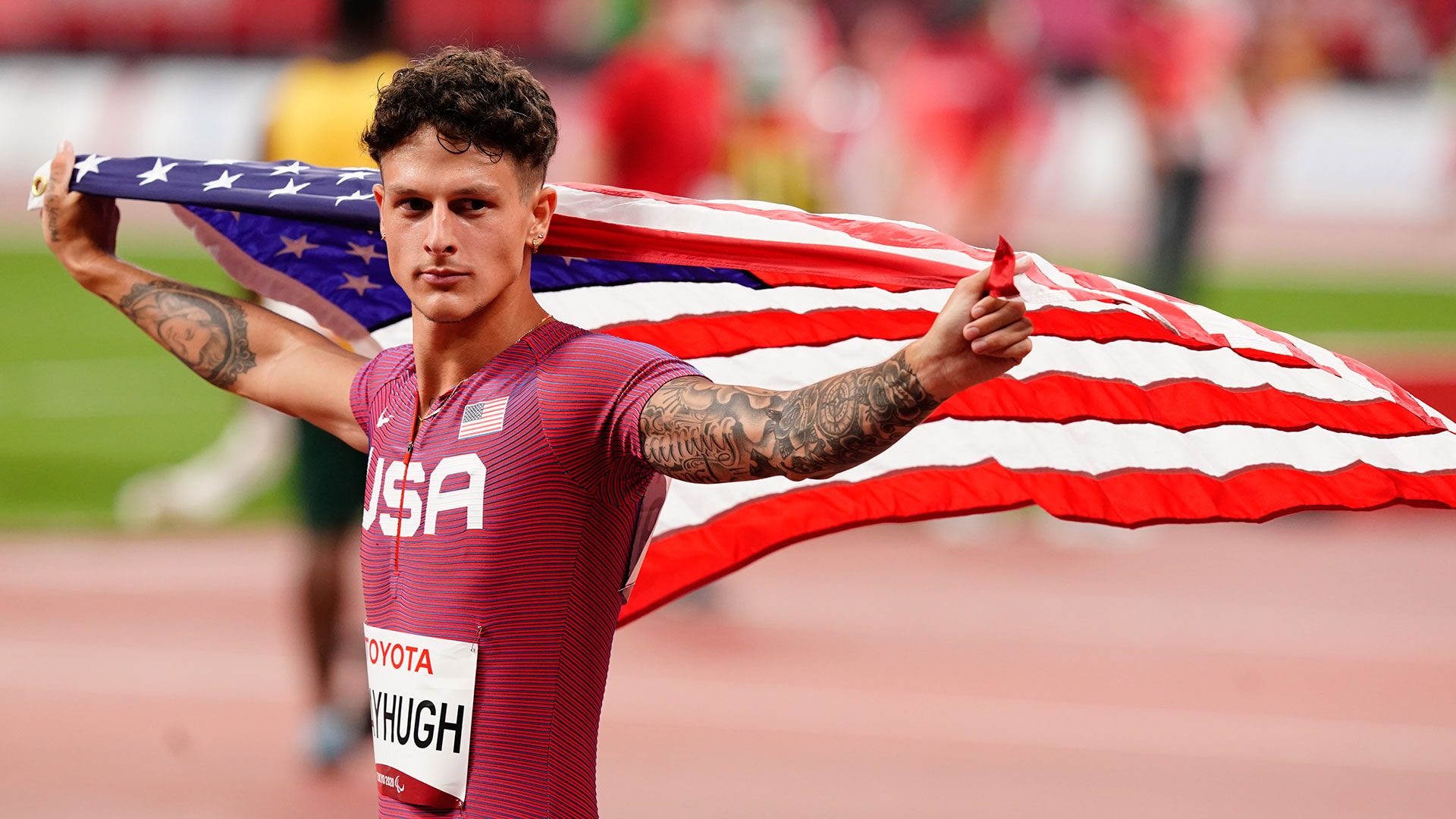 Nick Mayhugh arm tattoos while celebrating with the American flag