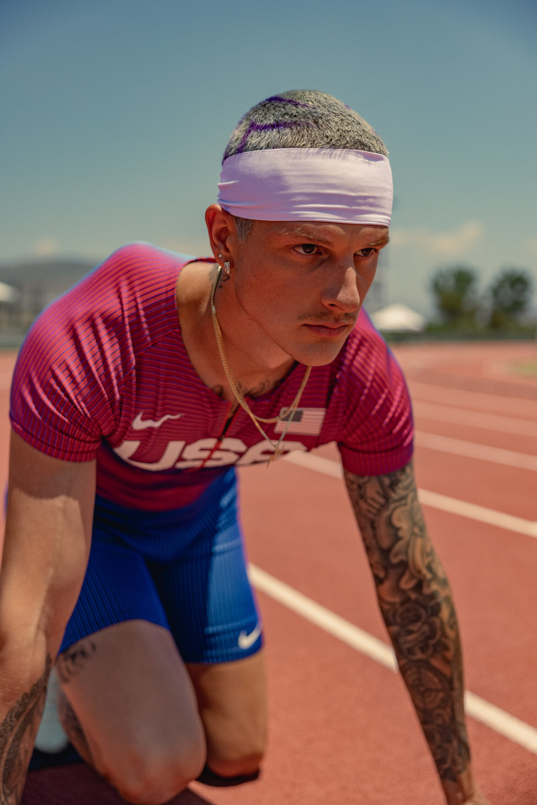 Nick Mayhugh track portrait showing his arm and neck tattoos