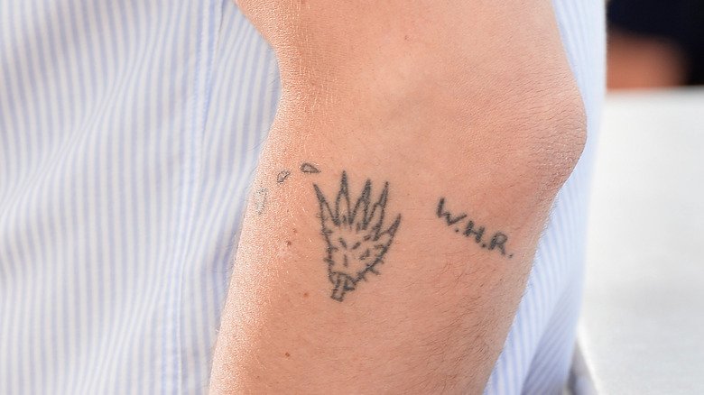 Ryan Gosling showing the homemade monster-hand tattoo on his forearm