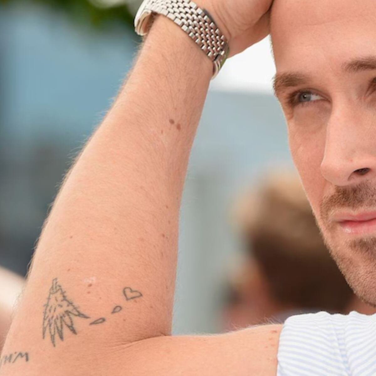 Ryan Gosling raising his arm to show several real tattoos