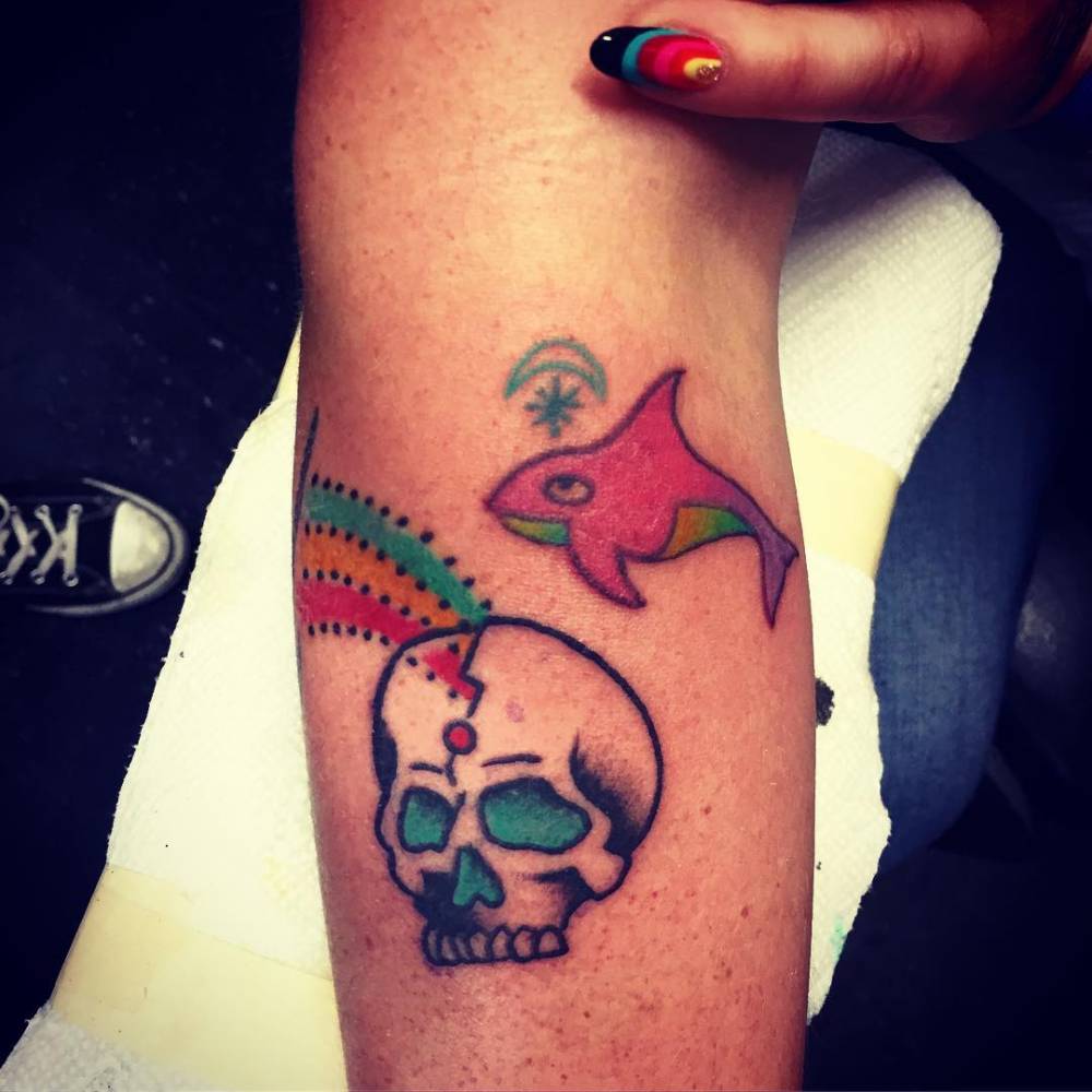 Kesha tattoos: close-up of Kesha's skull, rainbow and whale forearm tattoos