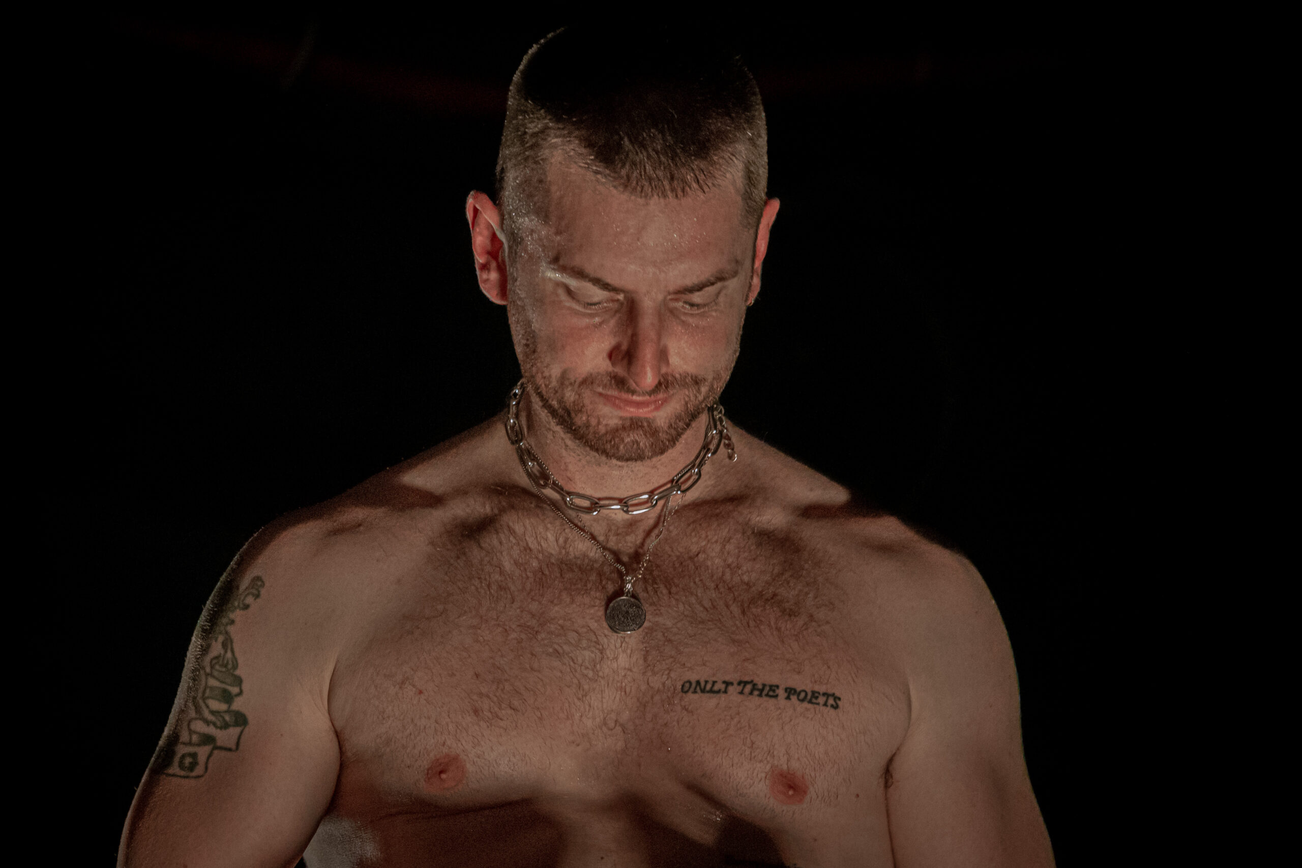 Marc E. Bassy tattooed torso during a live performance