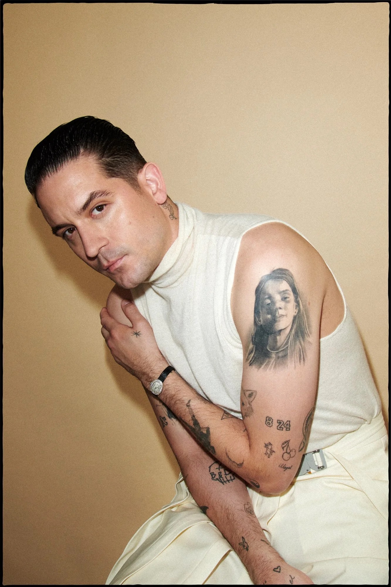 G-Eazy tattoos: upper-arm portrait and detailed forearm tattoo collection