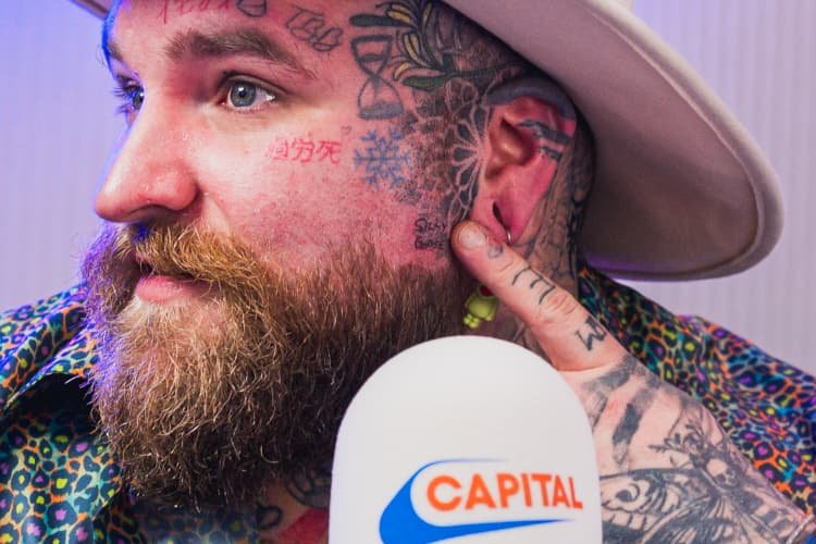 Close-up of Teddy Swims showing facial tattoos and cheek lettering
