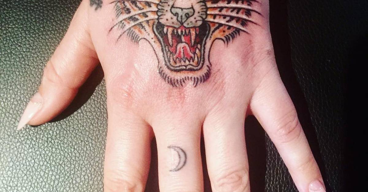 Kesha tattoos: close-up of Kesha's tiger hand and crescent finger tattoo