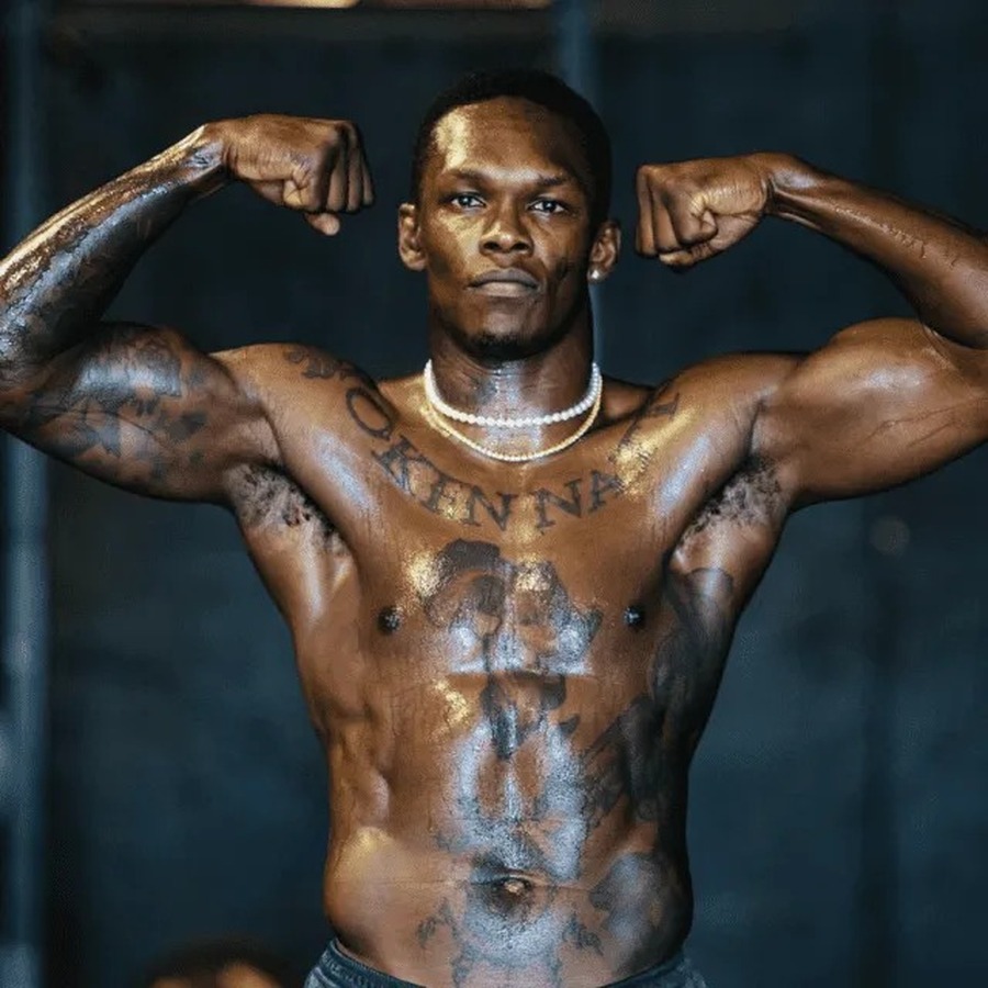 Israel Adesanya tattoos: separate weigh-in photograph showing the chest lettering and stomach tattoo map