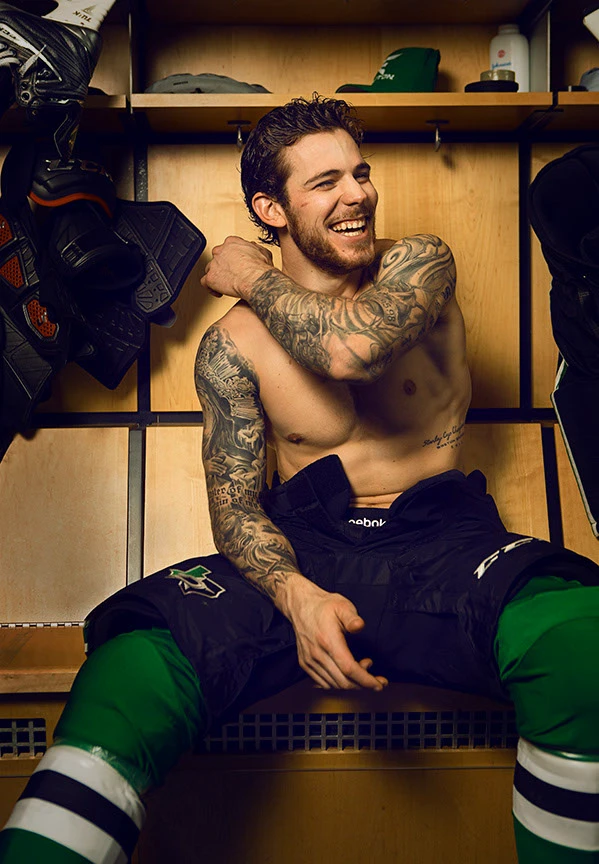 Tyler Seguin tattoos on his arms in a locker room portrait